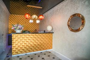 a room with a yellow wall with a mirror and lights at NOYA - Hotel Building Stefan Resort II in Mamaia Sat/Năvodari