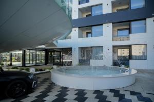 北马马亚-讷沃达里Hotel Building Stefan Resort II的一辆停在有喷泉的建筑物前的汽车