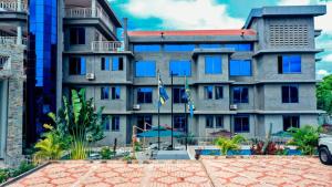 a large building with a flag in front of it at MK Hotel in Muisenge