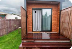 a small wooden house with a glass door at Lakeside Tiny Home in Cromwell