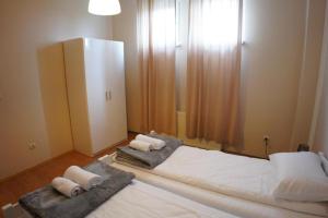 a bedroom with two beds and a dresser at Apartmani Kula - Apartman 2 in Novi Banovci