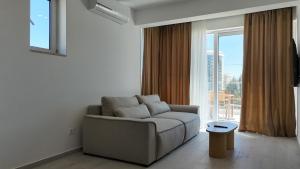 a living room with a couch and a large window at Alpesa Apartments in Budva