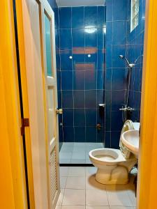 a blue tiled bathroom with a toilet and a sink at The Roof Tiles Hostel in Ho Chi Minh City