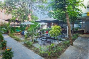 a patio with tables and chairs and umbrellas at Hotel Sapana Garden Thamel in Kathmandu