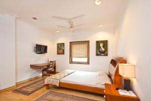 1 dormitorio con cama y escritorio en Trendy Bed & Breakfast, en Nueva Delhi