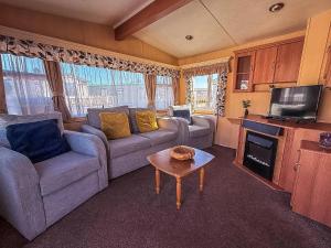 a living room with two couches and a tv at Spacious Caravan For Hire With Decking By The Beach In Suffolk Ref 40094Nd in Lowestoft +8 photos