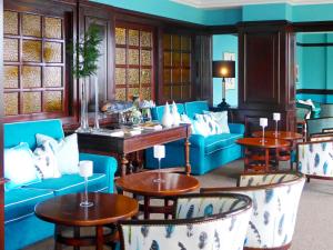 a lobby with blue couches and tables and windows at Pestana Bahia Praia Nature & Beach Resort in Vila Franca do Campo