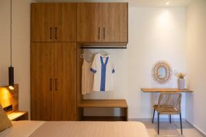 ein Schlafzimmer mit einem Bett und einem Holzschrank in der Unterkunft Aluna Boutique Suites in Vasilikos