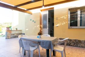 a dining room with a table and white chairs at Casa Vacanze Il Sole in Casamassella