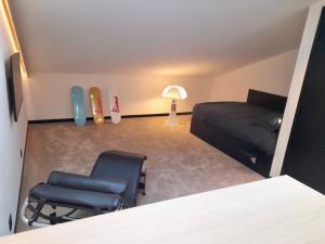 a room with a bed and two chairs and a lamp at Suite sous les toits 25m2 à 1mn du port de CASSIS in Cassis