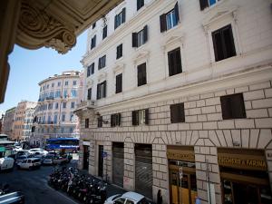 wysoki budynek z samochodami zaparkowanymi na ulicy miejskiej w obiekcie Rome Holiday Home w Rzymie