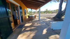 a porch of a house with a table and a tree at Cas Conco in Ciutadella