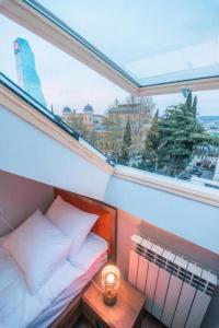 a small room with a bed and a window at Rooftop Apartments at Rustaveli Avenue in Tbilisi City