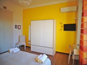 a bedroom with yellow walls and a large white cabinet at Kemonia in Palermo