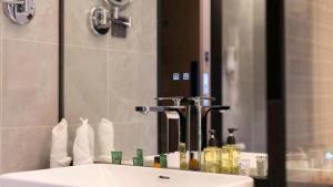 a bathroom sink with a large mirror and a sink at 沃德酒店济南经十东路融创文旅城店 in Jinan