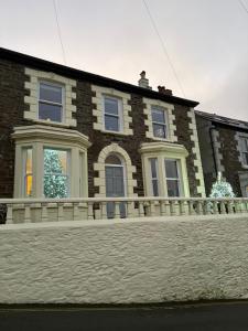 a brick house with a fence in front of it at What a view Mevagissey in Mevagissey
