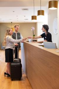 een groep mensen die handen schudden aan een balie bij Hôtel Terra Vinum in Gueberschwihr +56 foto's