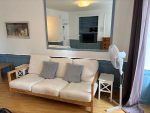a living room with a white couch and a mirror at Historical Center- Le Studio de St-Sauveur in Dinan