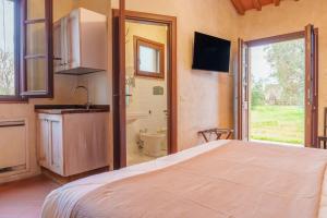 a bedroom with a bed and a sink and a bathroom at Casone Ugolino in Donoratico