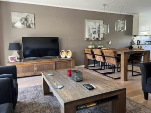 a living room with a television and a table at Perla di Robbie in Zandvoort