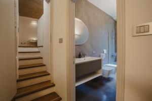 a bathroom with a sink and a tub and a toilet at Buk Apartment Citta Alta with garden view in Bergamo +11 photos