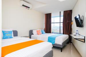 Postel nebo postele na pokoji v ubytování Sans Hotel Mataram Malioboro