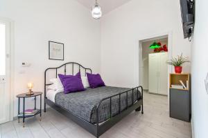 sypialnia z łóżkiem z fioletowymi poduszkami w obiekcie Casa Clara - Lecce Selection w mieście Lecce