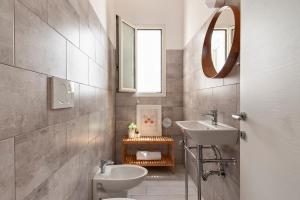 łazienka z umywalką, toaletą i lustrem w obiekcie Casa Clara - Lecce Selection w mieście Lecce