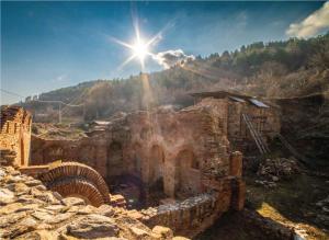 an old stone building with the sun in the sky at Tsar Samuil Hotel in Strumica