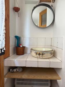 a bathroom with a bowl on a shelf with a mirror at YouMe, petit nid douillet in Aumessas
