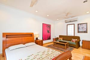 1 dormitorio con 1 cama grande y 1 sofá en Trendy Bed & Breakfast, en Nueva Delhi