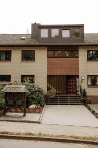 a large brick house with a porch and stairs at HeideHygge 2 in Schneverdingen