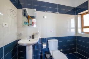 a blue and white bathroom with a toilet and a sink at Vila Eden in Ksamil +79 photos