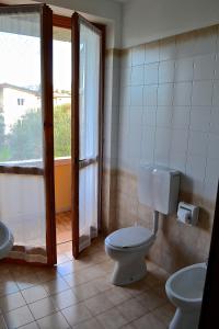 a bathroom with a toilet and a sink and a window at Residenza Benini in Bardolino