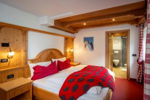 a bedroom with a large bed with red pillows at B&B Cesa Marlen in Canazei