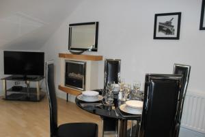 a dining room with a table and a tv at Bego's Apartment in Aberdeen