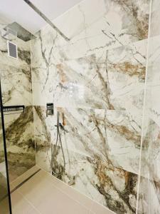 a bathroom with marble walls and a shower at Business Apartment Karlsruhe Südwest in Karlsruhe +17 photos