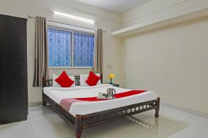 a bedroom with a large bed with red pillows at Hotel O Star in Kharadi