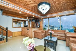 una sala de estar con un sofá y una mesa en Hotel View Point by THC Hotels - Manali, en Manali
