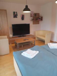 a living room with a blue bed and a tv at 1 Min to Metro I Balcony I 20 Min to Inner City in Vienna