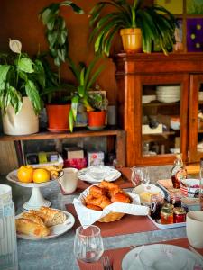 a table with plates of pastries and other foods at Le Clos des Roses - Chambre d'hôtes in Pérouges +18 photos