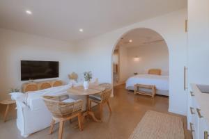 a bedroom with a bed and a living room with a table at Villa Alora in Exmouth