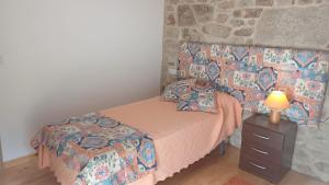 a bedroom with a bed and a table with a lamp at Casa Diaz in Cea