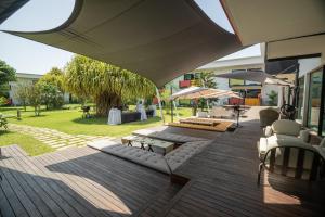 a patio with couches and tables and umbrellas at ONOMO Hotel Abidjan in Abidjan