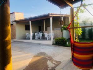 een huis met witte stoelen en een patio bij Chácara GLclube 