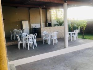 een groep witte stoelen en tafels op een patio bij Chácara GLclube  +4 foto's