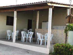 een groep witte stoelen op een terras bij Chácara GLclube 