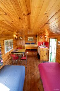 una stanza con un letto, un tavolo e delle sedie di Manoir du Bois Joly - Roulotte Vintage a Margon Altre 29 foto