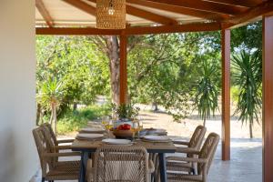 einem Holztisch mit Stühlen und einem Tisch am Tisch am Tisch am Tisch am Tisch am Tisch am Tisch am Tisch am Tisch am Tisch am Tisch am Tisch am Tisch am Tisch am Tisch am Tisch am Tisch am Tisch am Tisch am Tisch am Tisch am Tisch am Tisch am Tisch am Tisch am Tisch am Tisch am Tisch am Tisch am Tisch am Tisch am Tisch am Tisch am Tisch am Tisch am Tisch am Tisch am Tisch am Tisch. in der Unterkunft Aluna Boutique Suites in Vasilikos