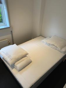a bed with white sheets and pillows on it at The old bank in Sønderborg +15 photos